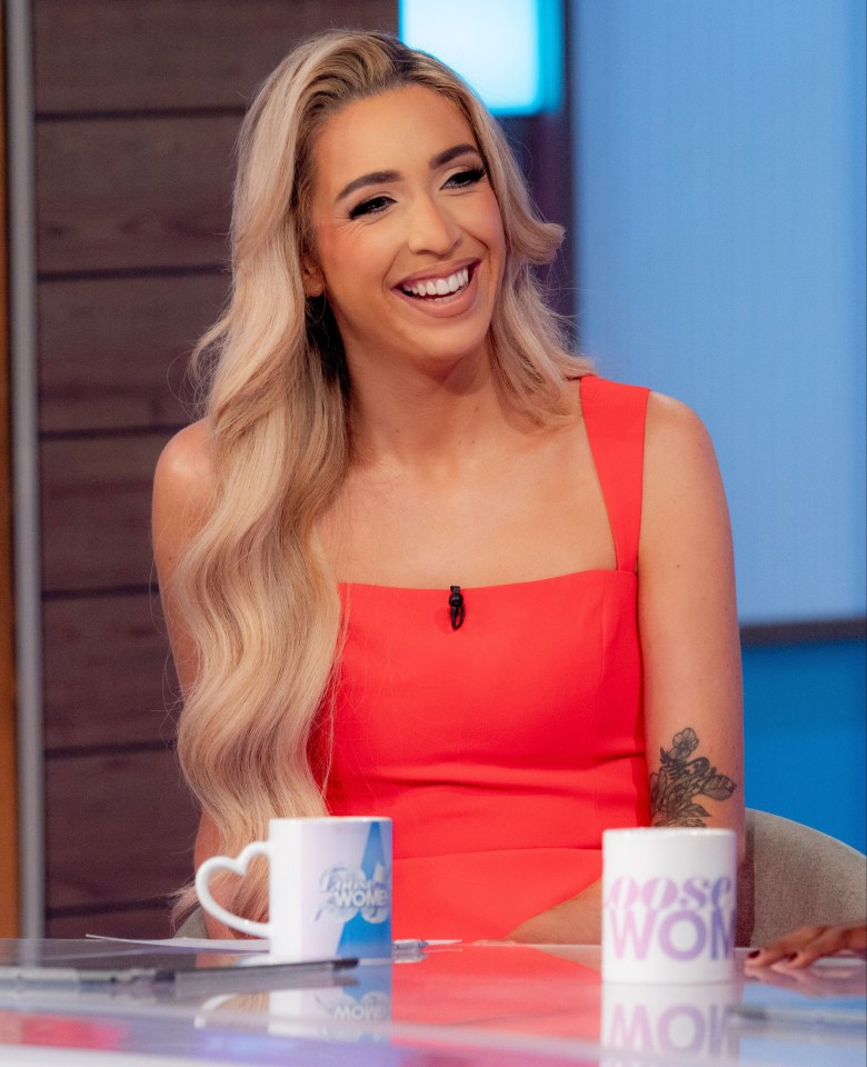 a woman in a red dress sits at a table with a cup that says ' female wow ' on it