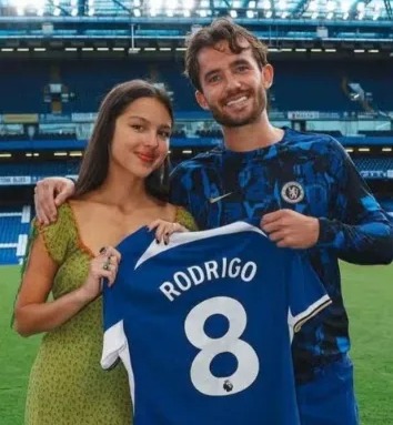 a man and a woman are holding a soccer jersey with the number 8 on it .