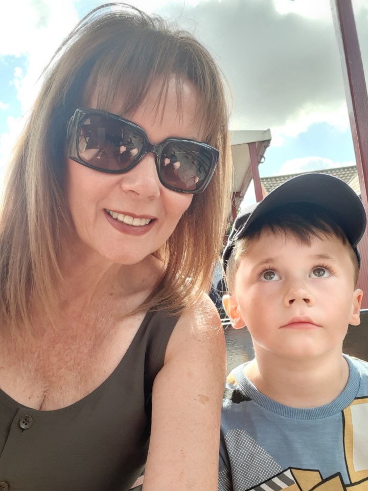 a woman wearing sunglasses sits next to a young boy wearing a hat