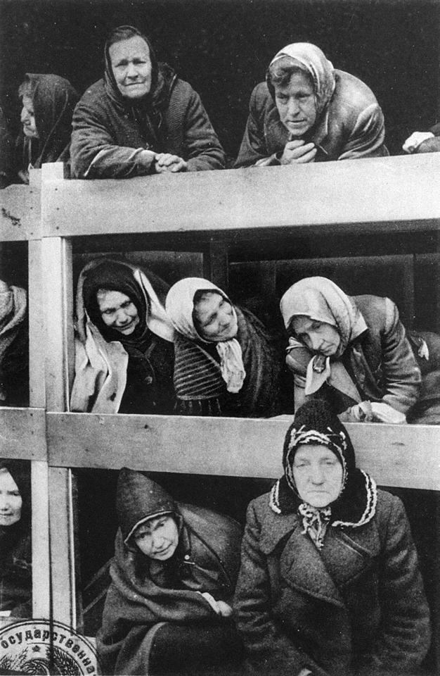 a black and white photo of a group of women in bunk beds