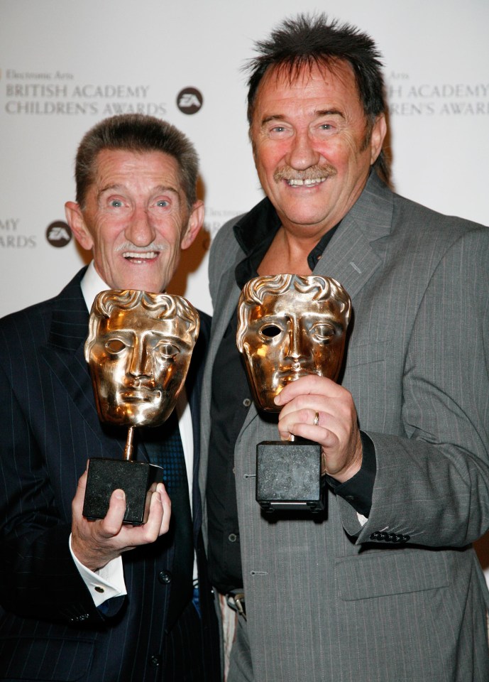 two men holding trophies at the british academy children 's awards