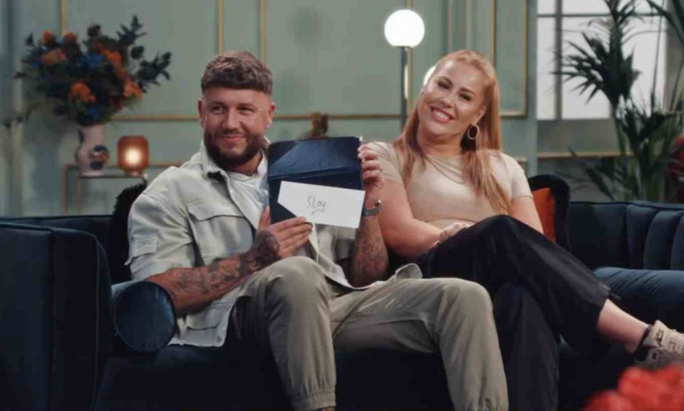 a man and a woman sit on a couch holding a piece of paper that says stay