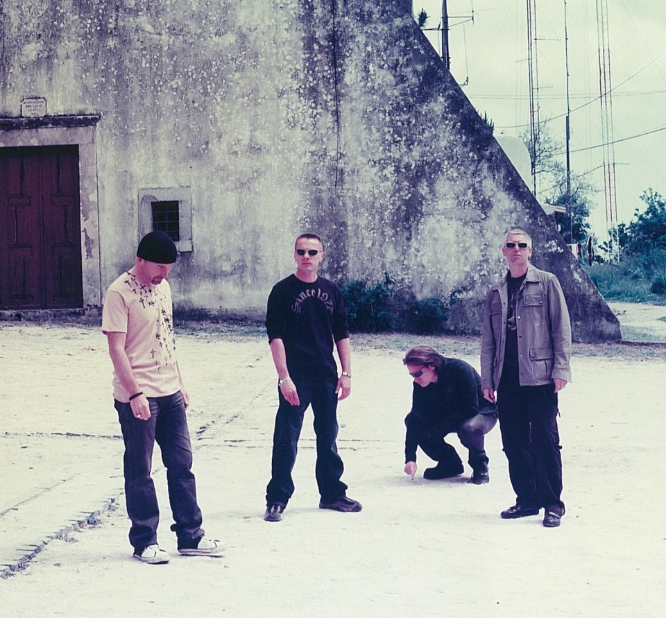 a group of men are standing in front of a building that has a cross on it