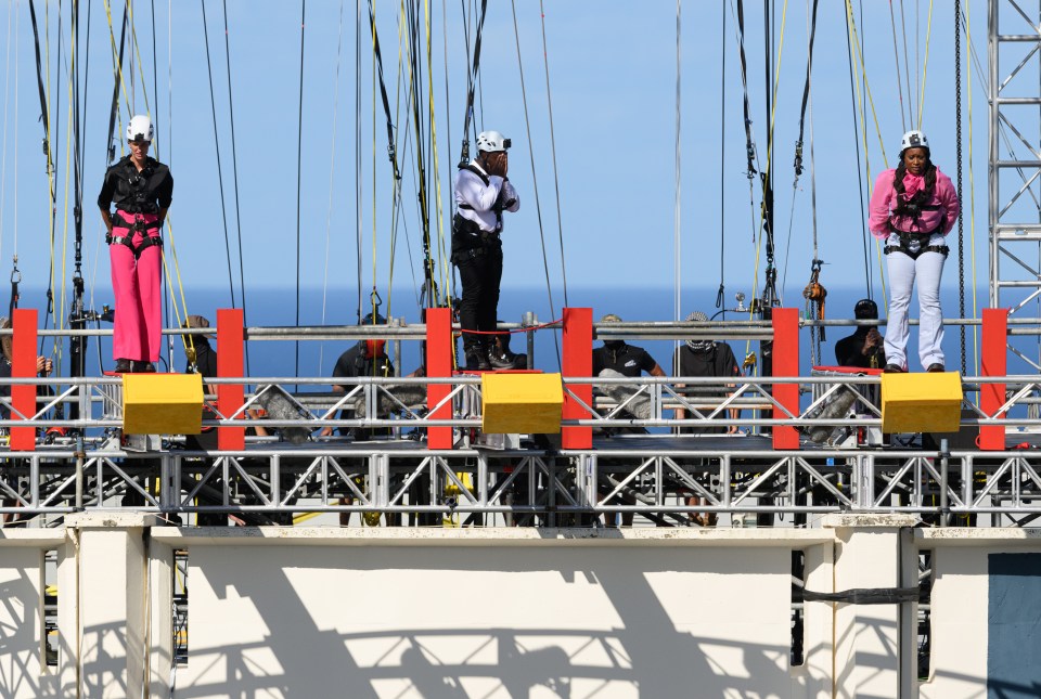 a group of people standing on top of a very tall structure