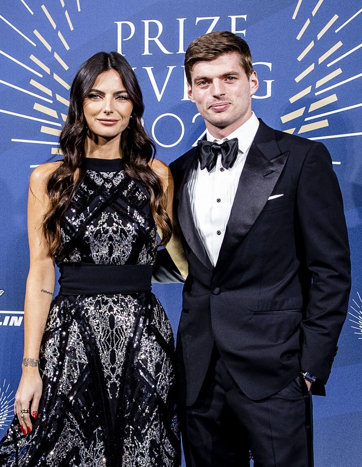 a man and woman pose for a photo in front of a sign that says prize