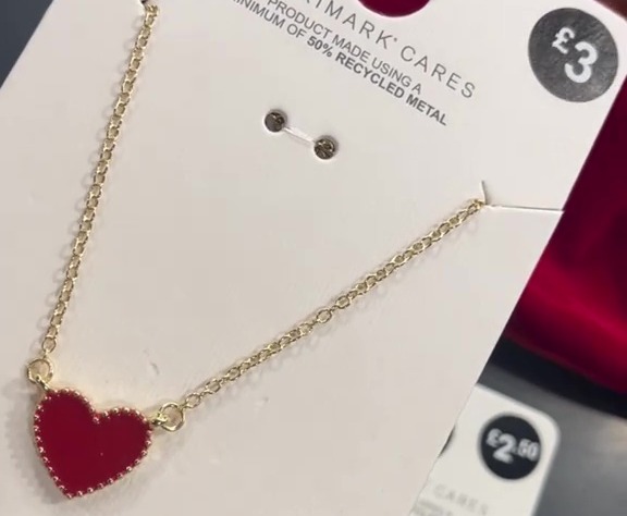 The necklace features a red heart with gold dots around the edge