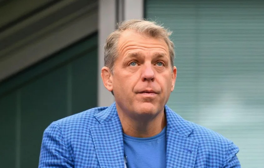 a man wearing a blue jacket and a blue shirt with the letter w on it