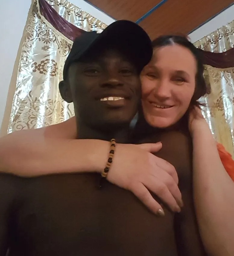 a man wearing a black hat and a woman wearing a bracelet are posing for a picture