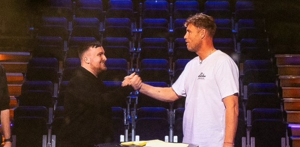 a man wearing a white t-shirt that says abercrombie shakes hands with another man