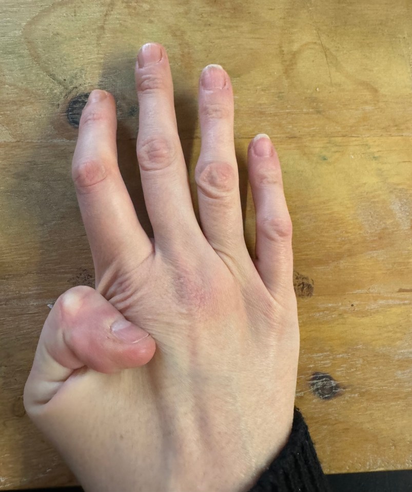 a close up of a person 's hand on a wooden table