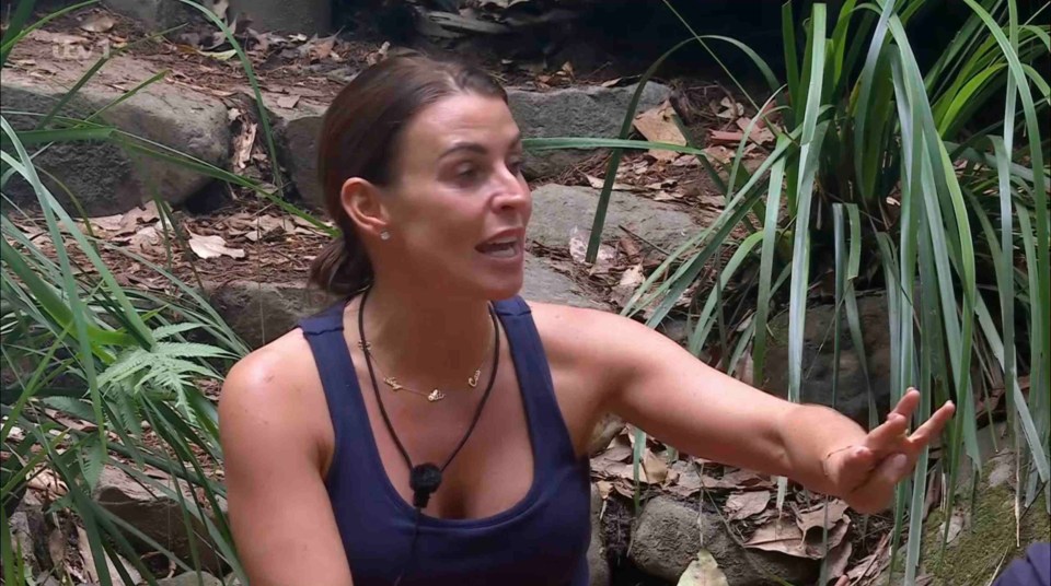 a woman in a blue tank top is sitting in the jungle