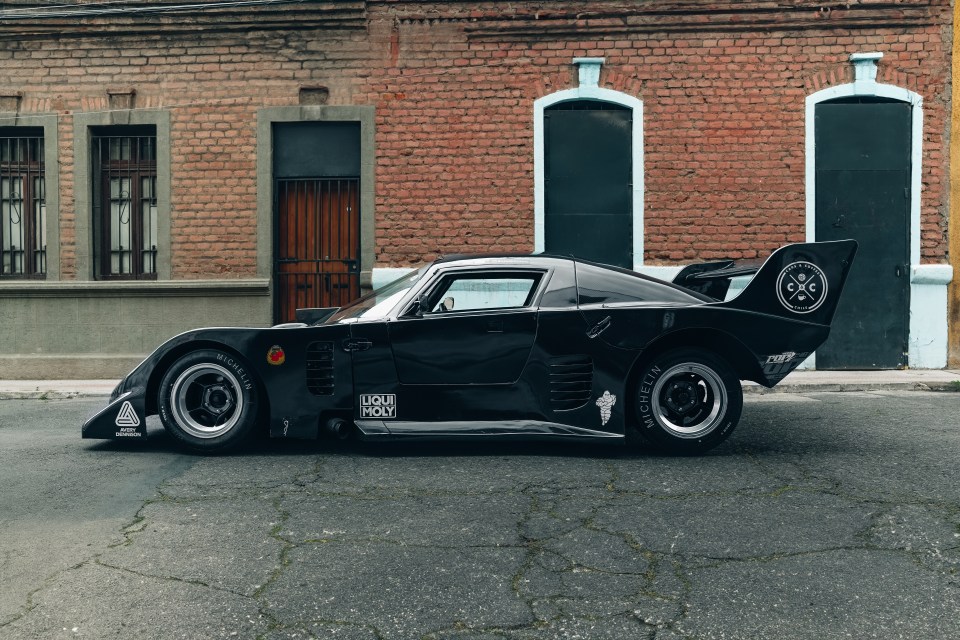 a black liqui moly car is parked in front of a brick building