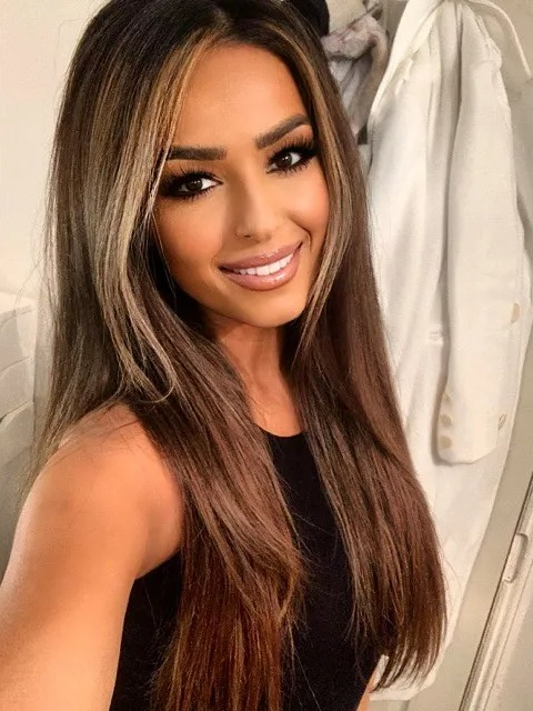 a woman with long brown hair is smiling for the camera