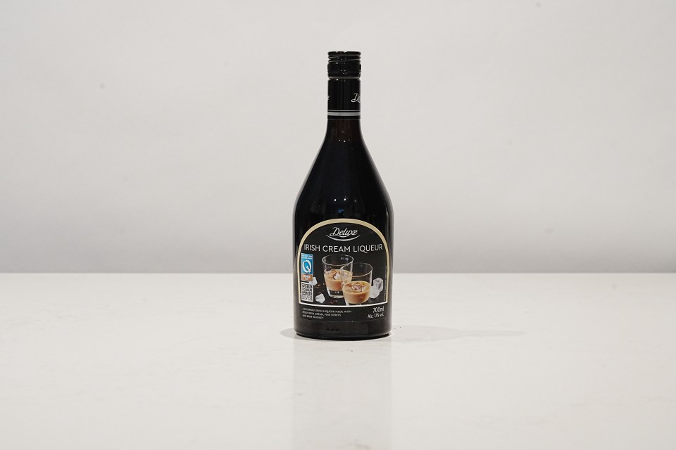 a bottle of deluxe irish cream liqueur sits on a white surface