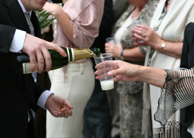 a bottle of champagne is being poured into a plastic cup