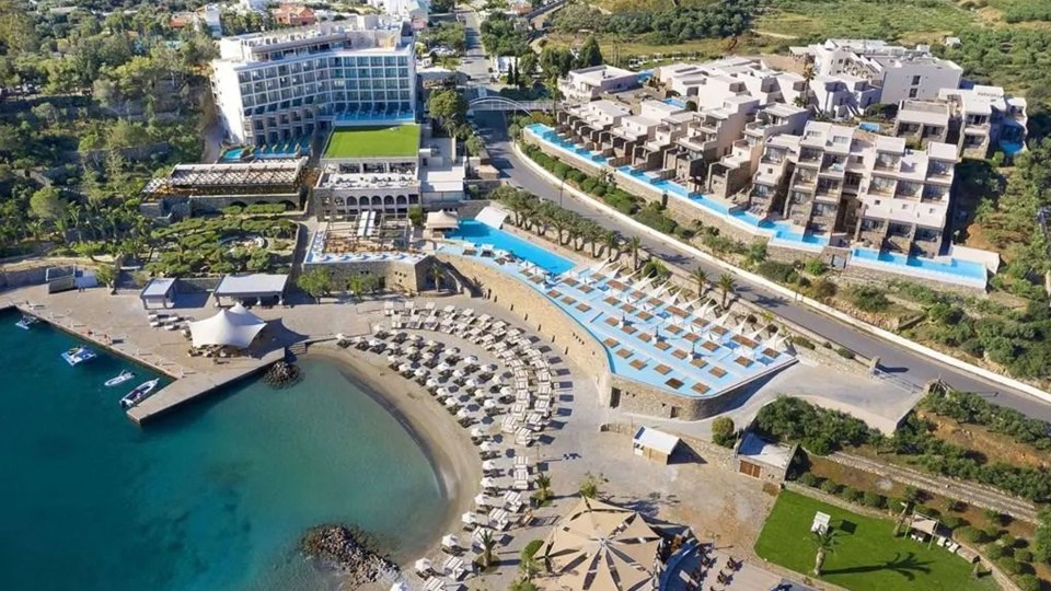 an aerial view of a beach resort with a large building in the background