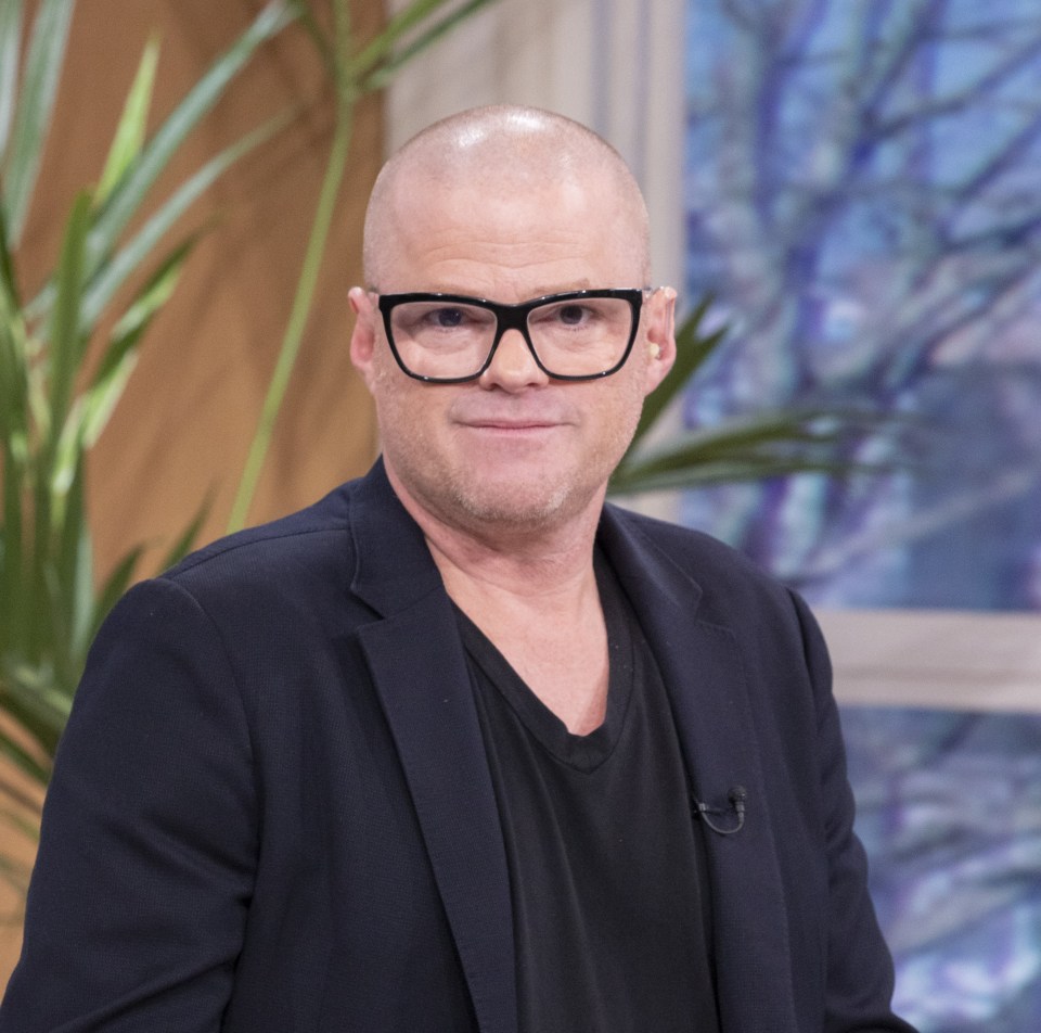 a bald man wearing glasses and a black jacket