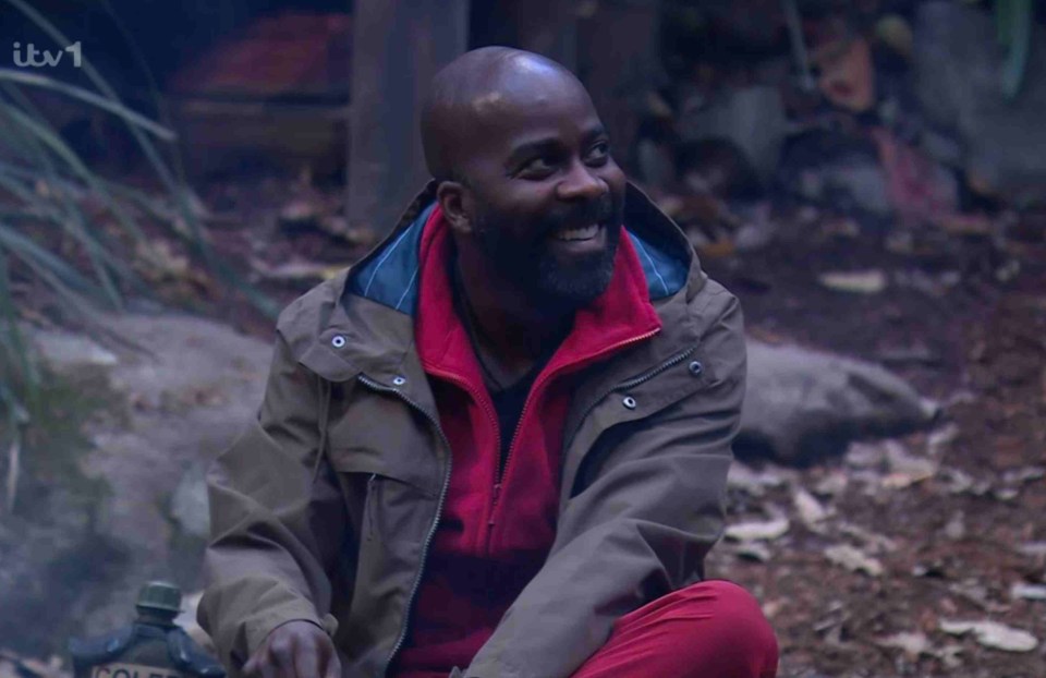 a man sitting in the woods with a coleen bottle in front of him