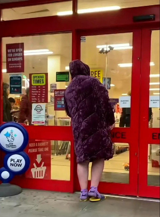 The woman, dressed in a purple dressing gown and sliders, was blocked from entering