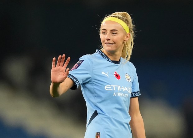 a woman in a blue etihad airways jersey waves her hand