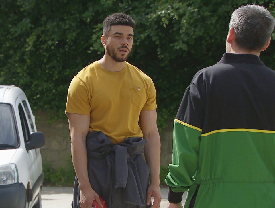 a man in a yellow shirt is talking to another man in a green jacket