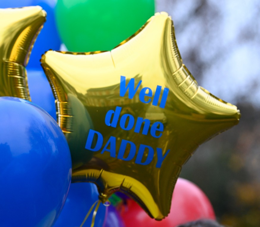 She picked up huge bunches of balloons - including one with the message 'well done daddy'