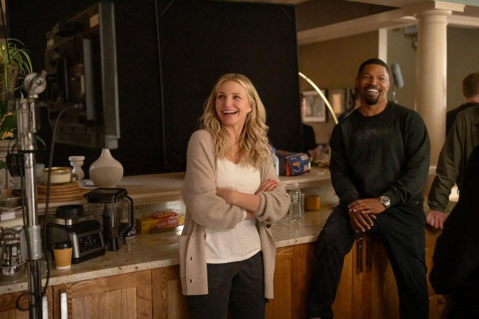 a man and a woman are sitting on a counter laughing