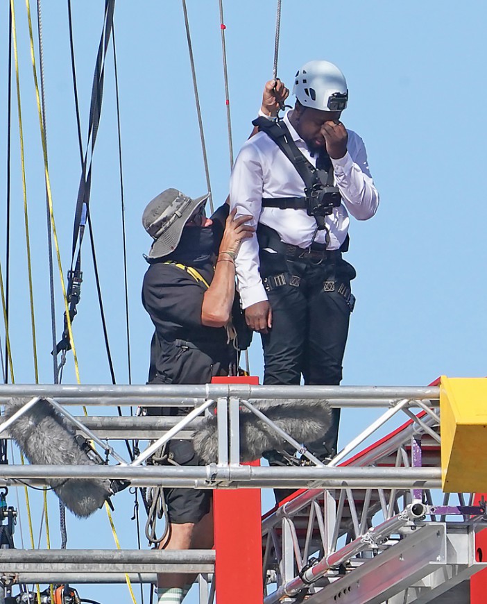 a man wearing a white shirt and black pants has a helmet on