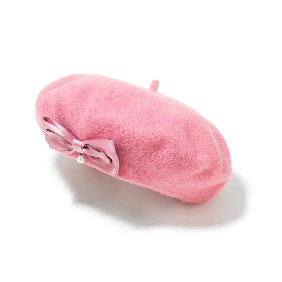 a pink beret with a bow and pearls on it