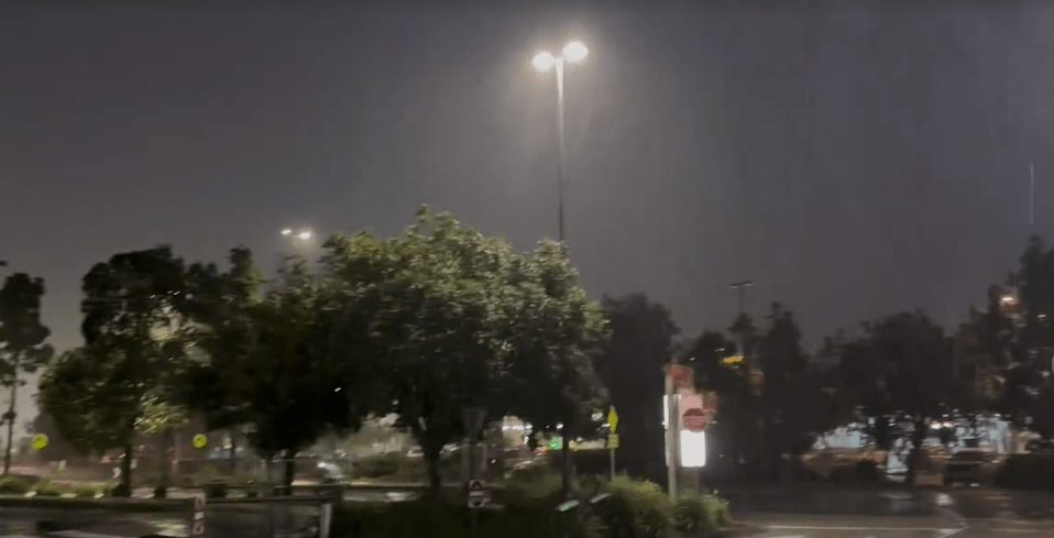 a stop sign is lit up at night in a parking lot