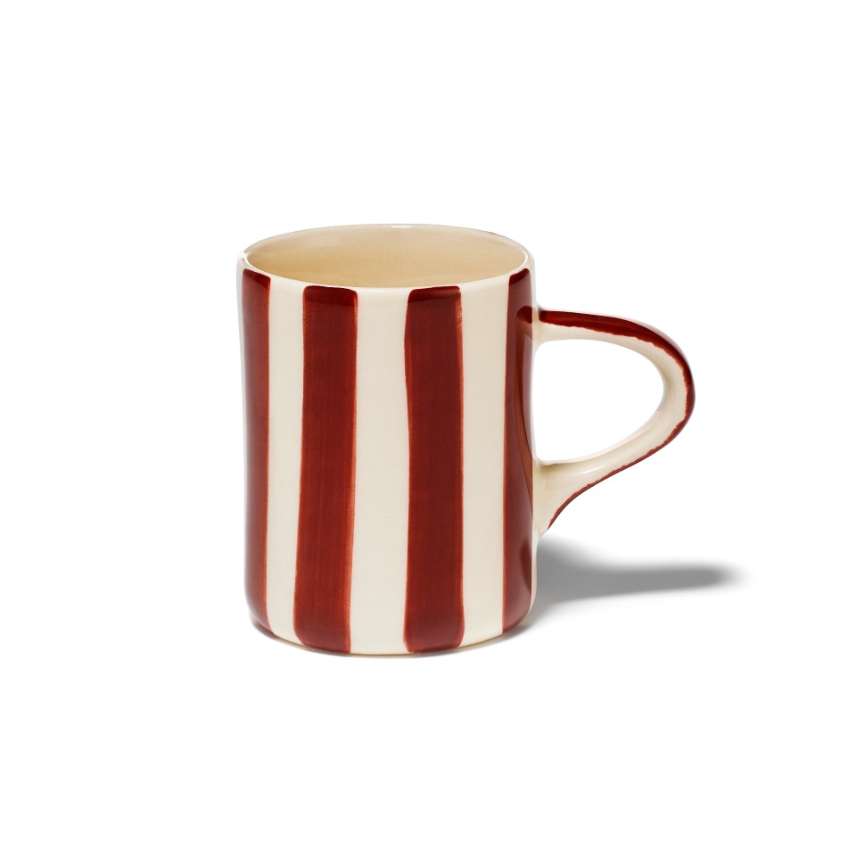 a red and white striped mug with a handle