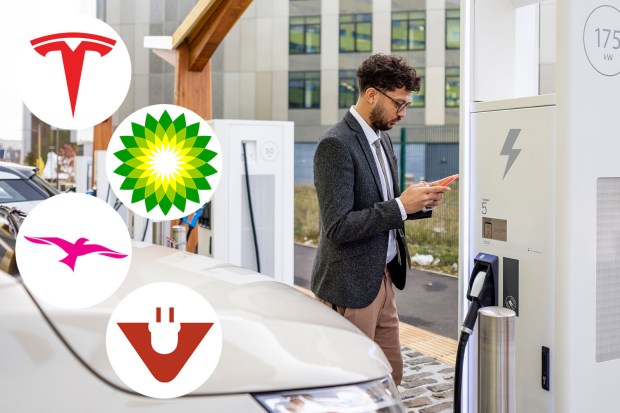 a man is charging an electric car at a charging station