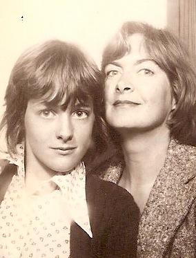 a black and white photo of a woman and a boy posing for a picture .