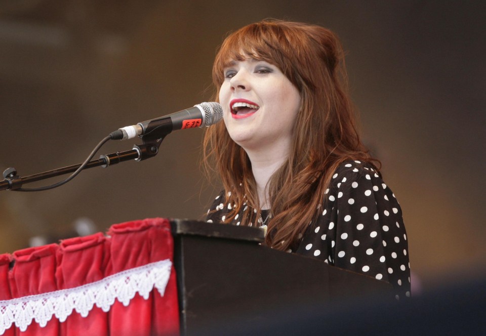 a woman singing into a microphone with the number f32 on it