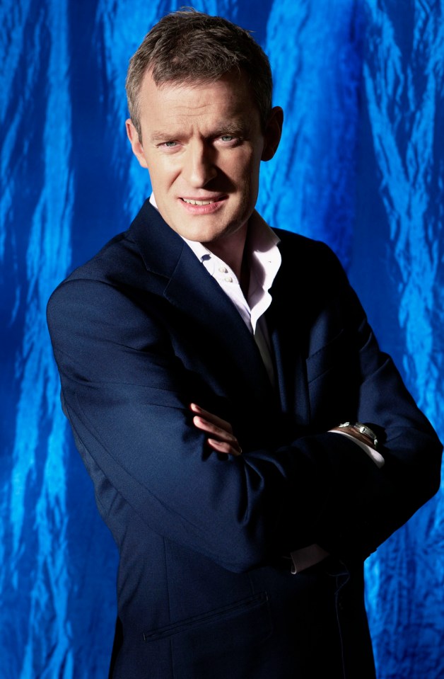 a man in a suit stands with his arms crossed in front of a blue background