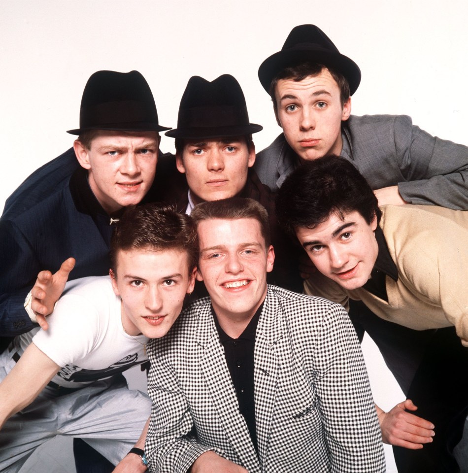 a group of young men posing for a picture with one wearing a shirt that says ' a ' on it