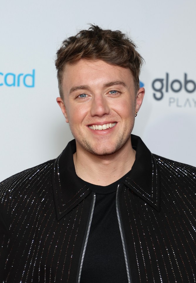 a man is smiling in front of a sign that says globe play