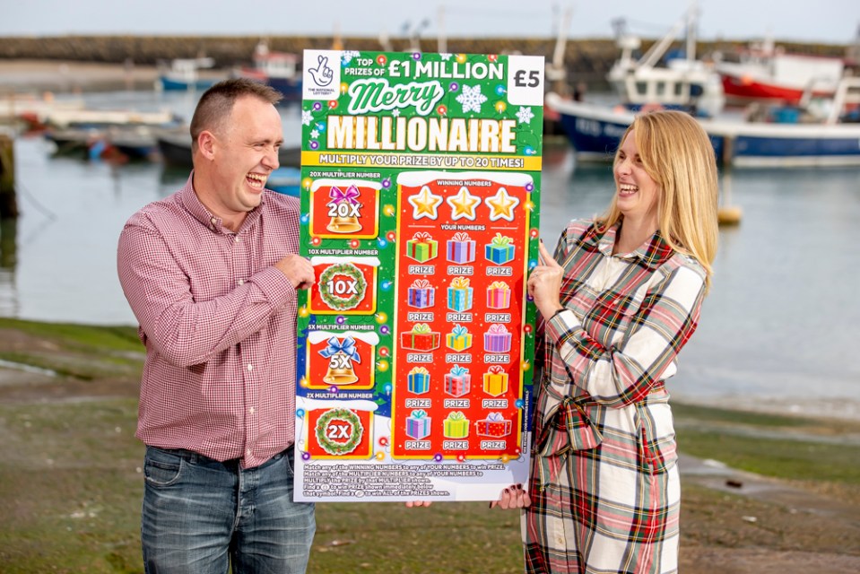 a man and a woman holding a poster that says merry millionaire