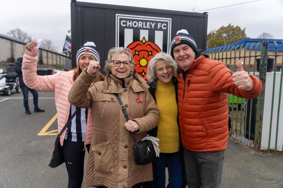 a group of people standing in front of a sign that says chorley fc