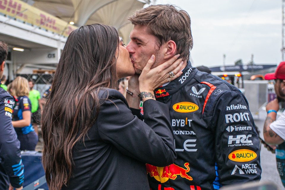 a woman kisses a man wearing a red bull jacket