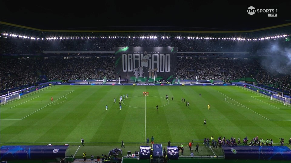 a soccer field with a banner that says obrigado