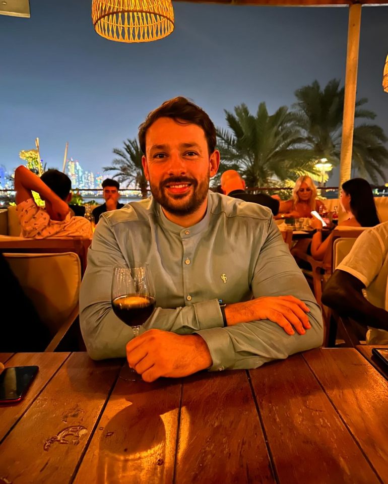 a man sitting at a table with a glass of wine