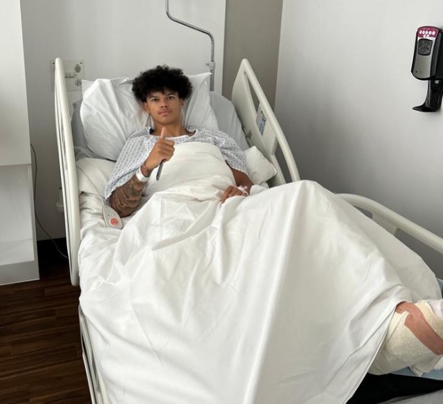 a man in a hospital bed with a thumbs up