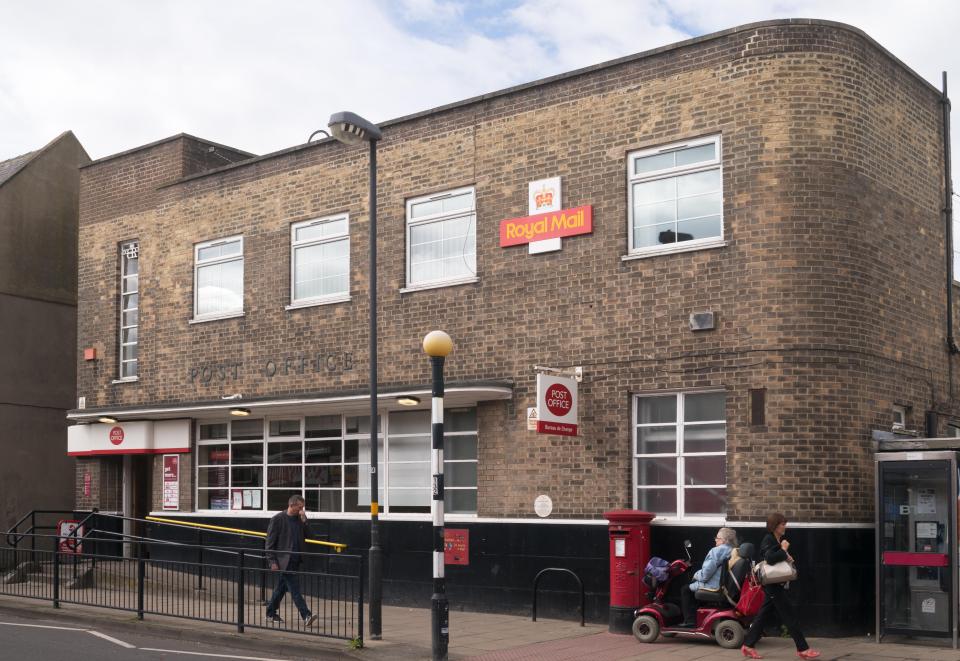 a post office with a red sign that says royal mail