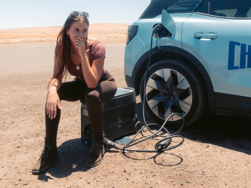 a woman sits next to a car that has the word ch on it