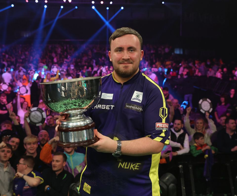 a man holding a trophy with the word nuke on his shirt