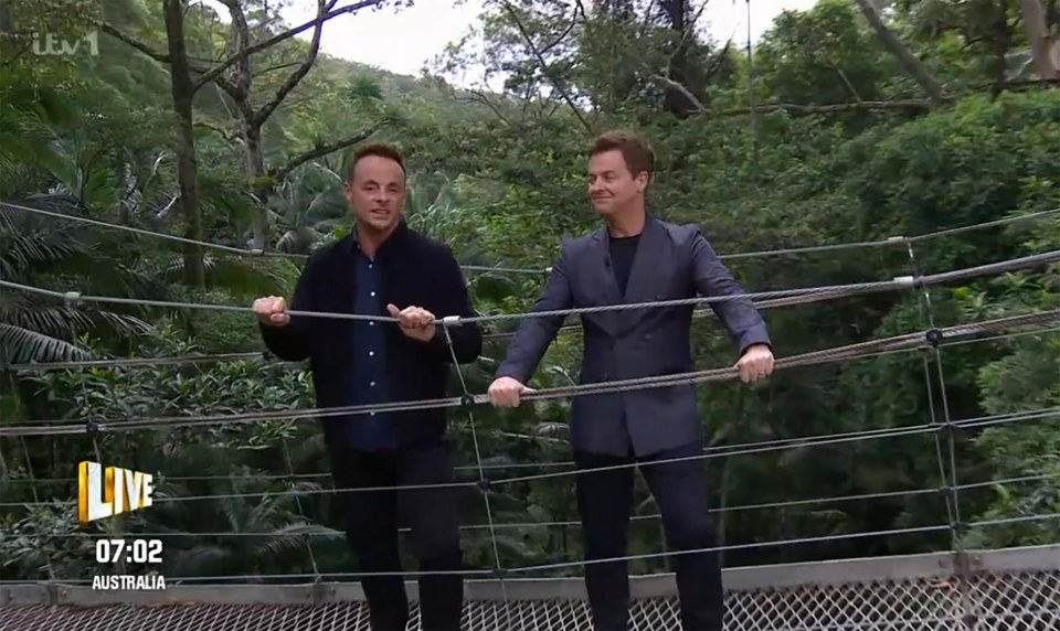 two men standing on a bridge with the time of 07:22