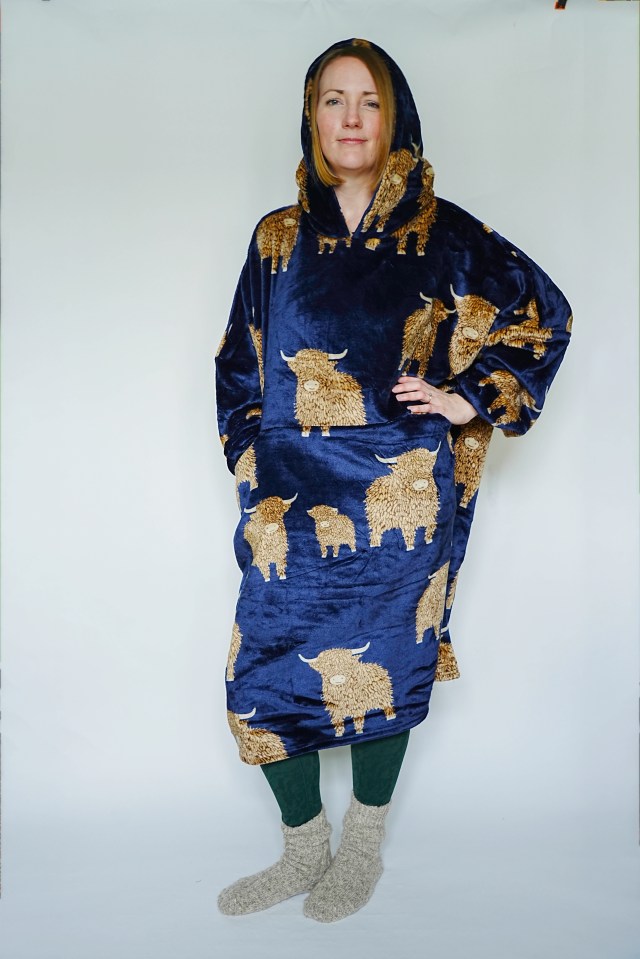 a woman wearing a blue blanket with bulls on it