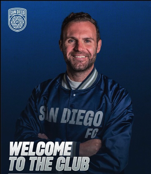 a man wearing a san diego fc jacket with his arms crossed