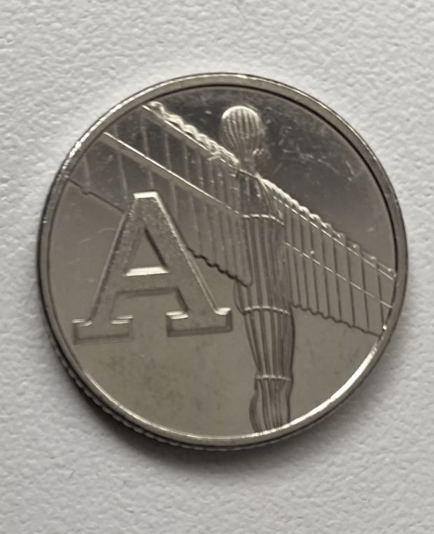 a silver coin with the letter a on it